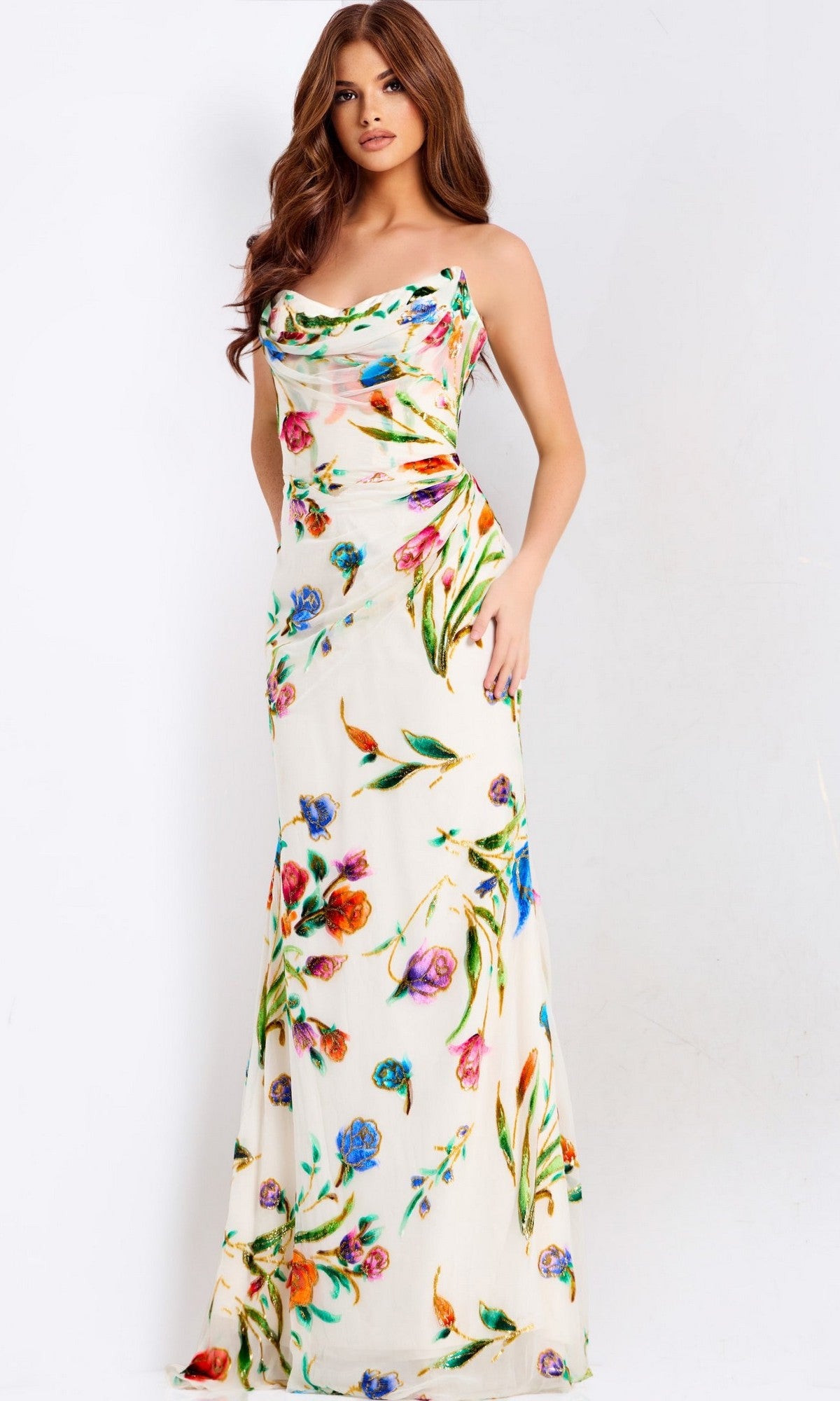 A woman poses against a plain light background, wearing the Jovani 47626 long prom dress—a sleeveless white satin gown with a colorful floral print.